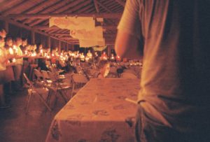 a group of young people stand around a circle holding candles and singing